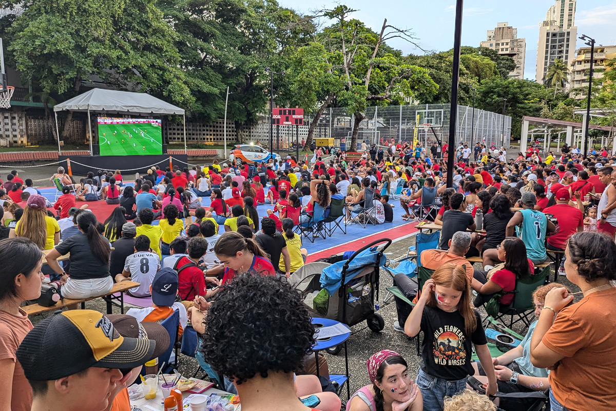 The community gathers in the park to watch a soccer match.