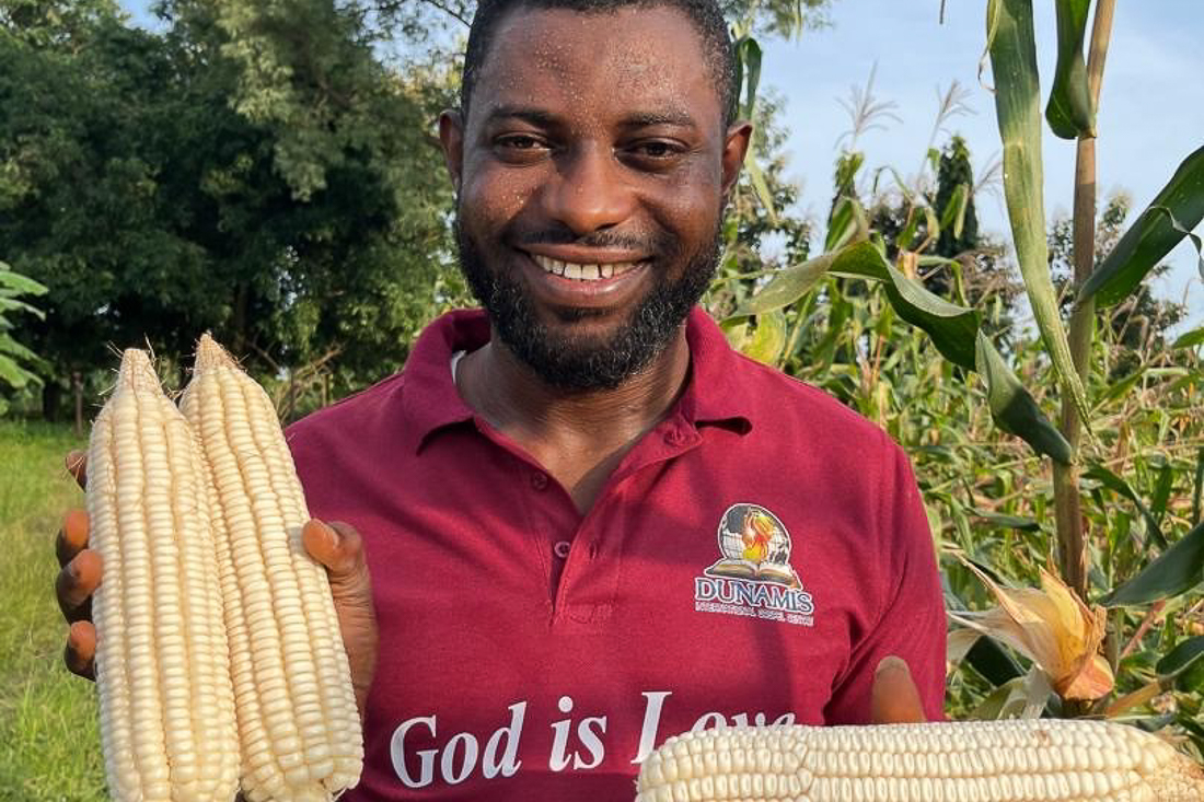 Nigerian farmer shows off his corn harvest. 